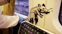Un empregado do metro de Londres borra unha obra de Banksy