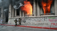 Centos de manifestantes asaltan o Congreso de Guatemala e préndenlle lume